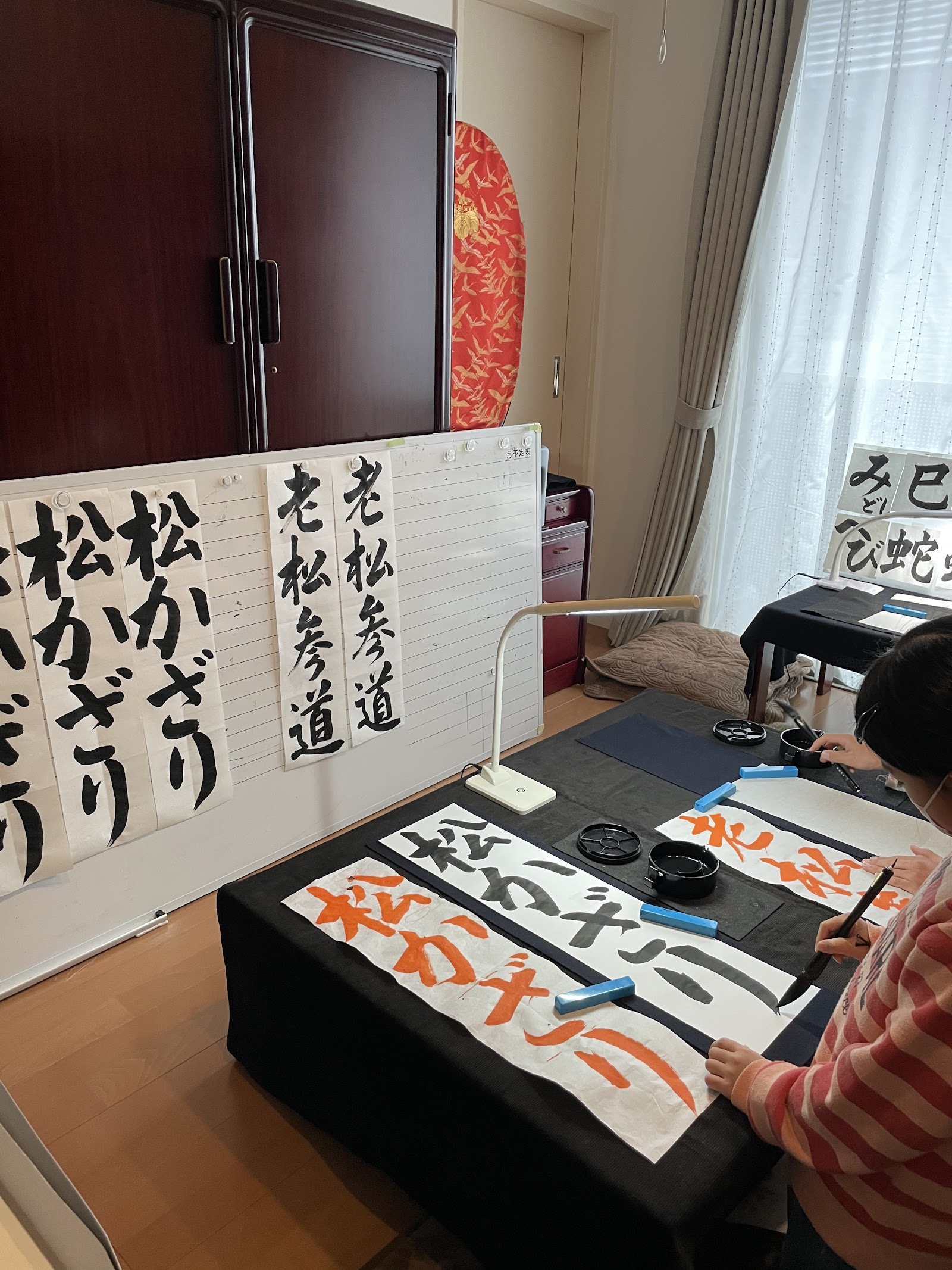生徒が筆で「松かざり」を書いている様子